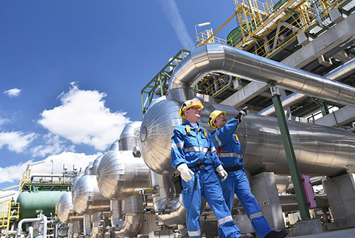 industrial workers in a refinery oil processing equipment and machinery